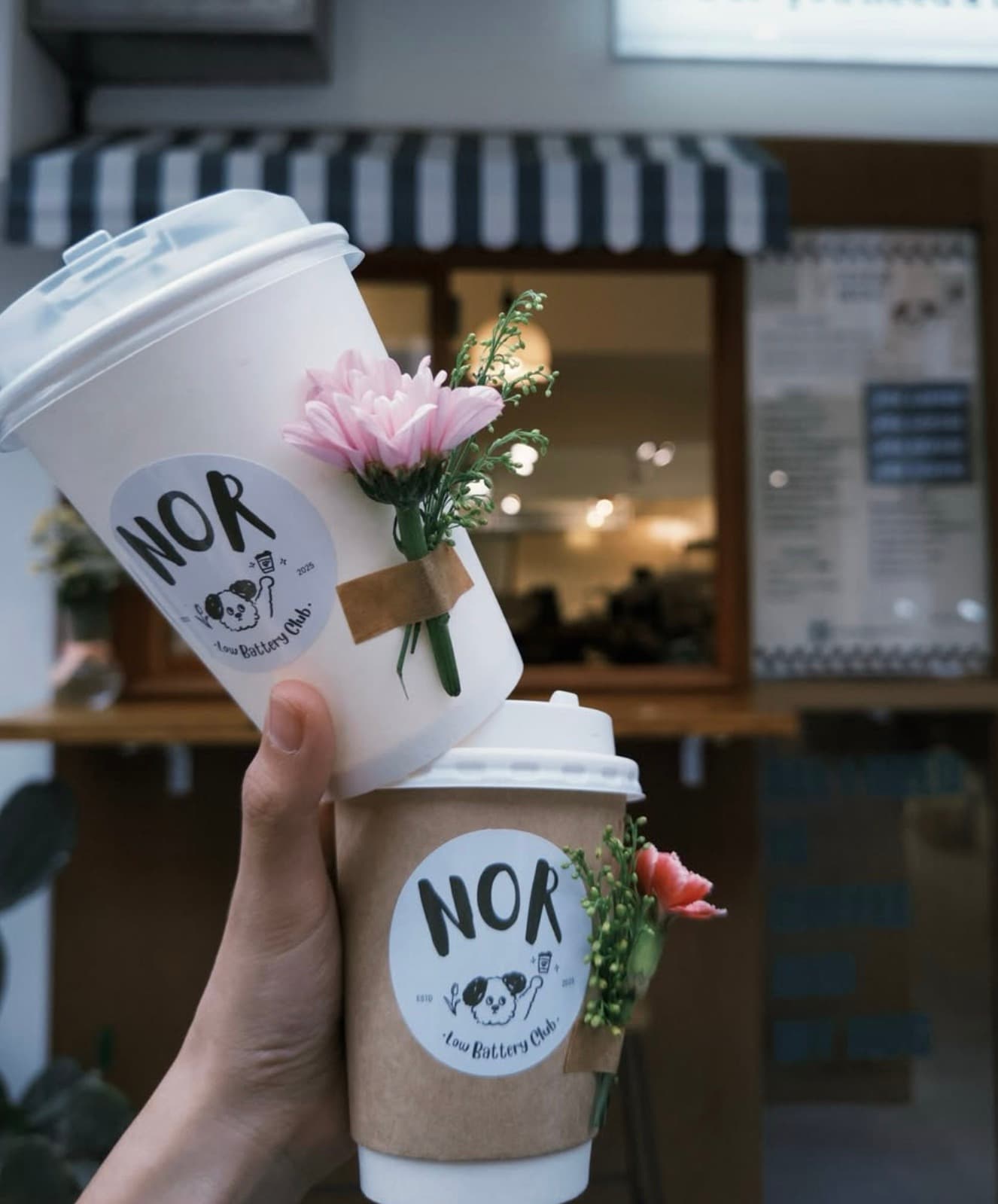 Holding two NOR Coffee cups in front of the shop on Lane 53, Chifeng Street, Taipei